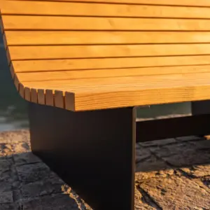 Detail der Liegebank Lützelau: Stirnseiten der Lärchenlatten über der schwarzen Stahlplatte im Abendlicht (Visualisierung)