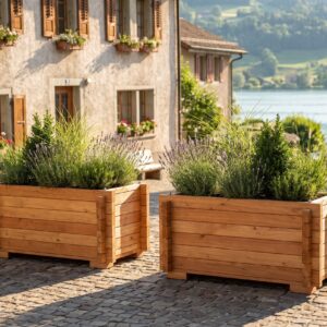 Zwei Pflanzkübel Jona aus Lärche mit Gräsern und Lavendel auf einem gepflasterten Dorfplatz am See (Visualisierung)