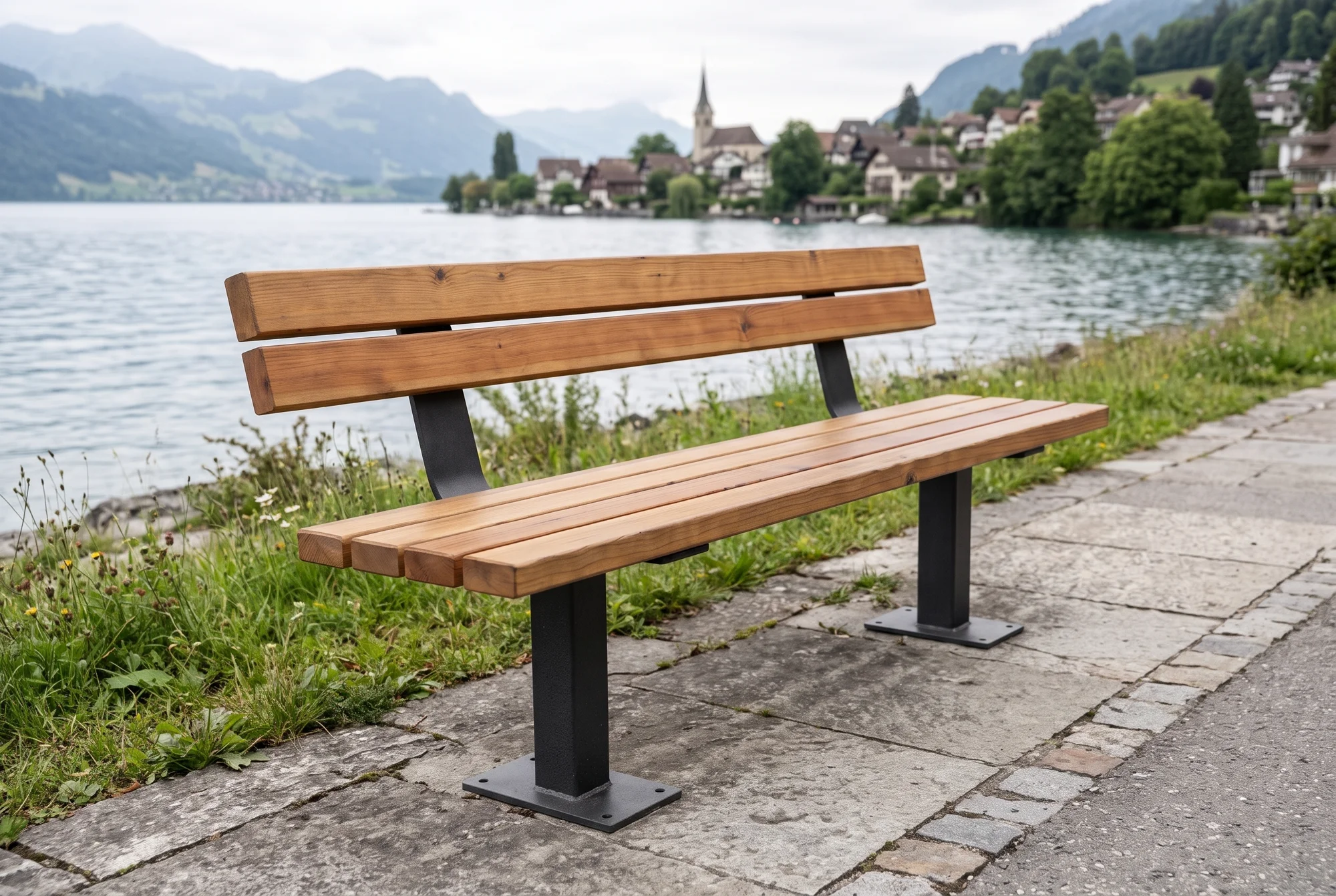 Sitzbank Ufenau mit Lehne, Stütze aus Vierkantrohr, an einem Uferweg neben einer Wiese, im Hintergrund See und Dorf (Visualisierung)